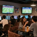 Sports enthusiasts enjoying the betting experience at https://red88m7.com with live event displays and a vibrant atmosphere.